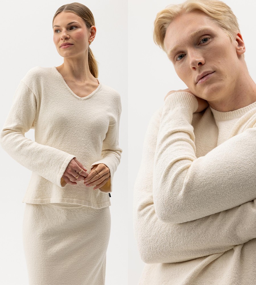 Flera stickade plagg som hänger på galge på en klädställning