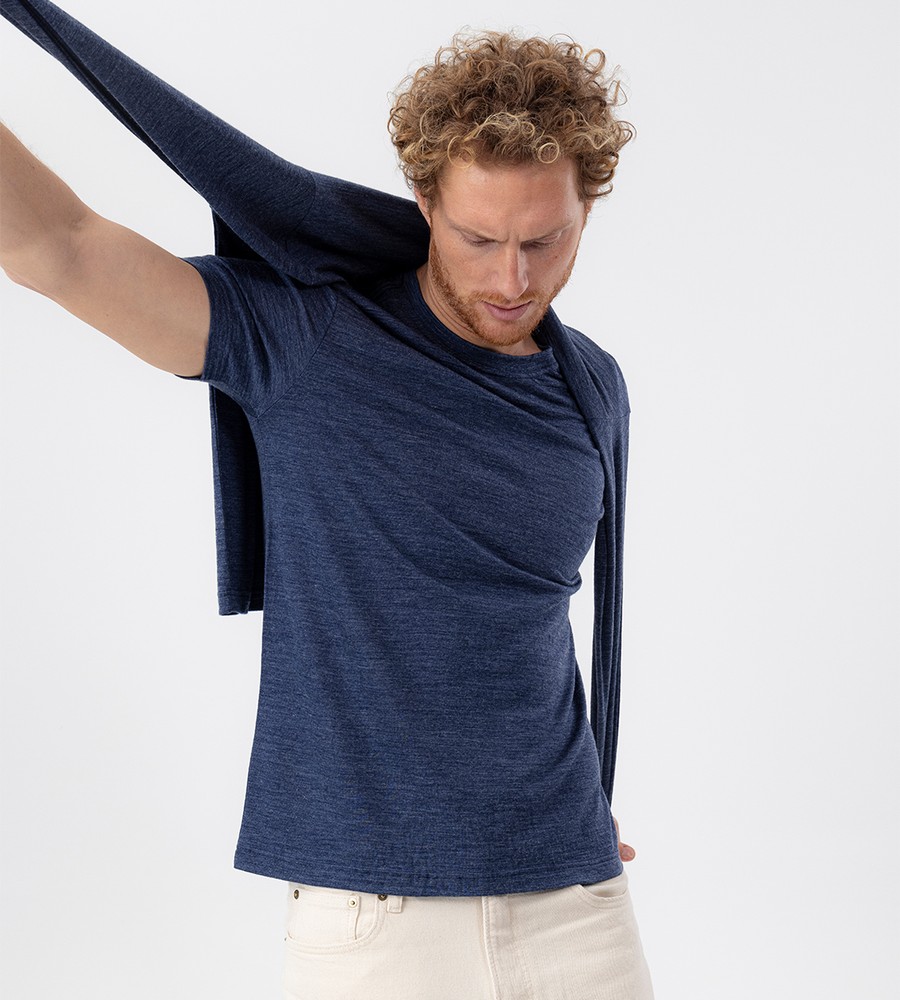 Flera stickade plagg som hänger på galge på en klädställning