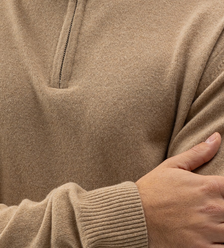 Kvinna och man går längst med strandkanten och bär linneplagg