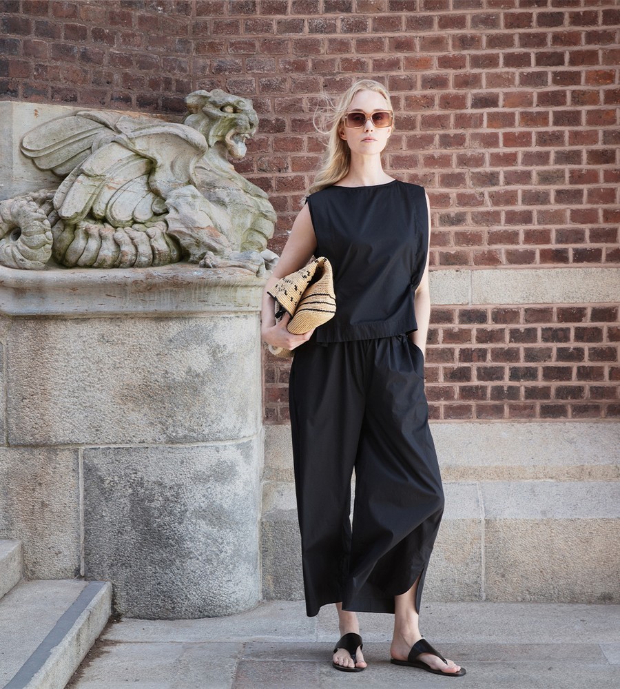 Flera stickade plagg som hänger på galge på en klädställning