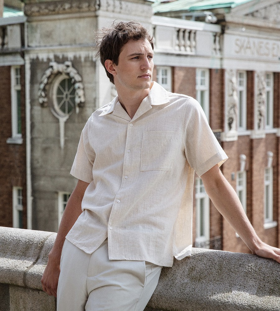 Flera stickade plagg som hänger på galge på en klädställning