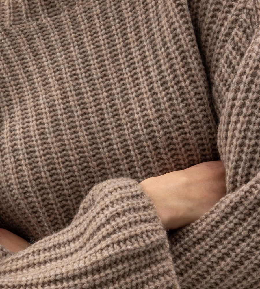 Kvinna och man går längst med strandkanten och bär linneplagg