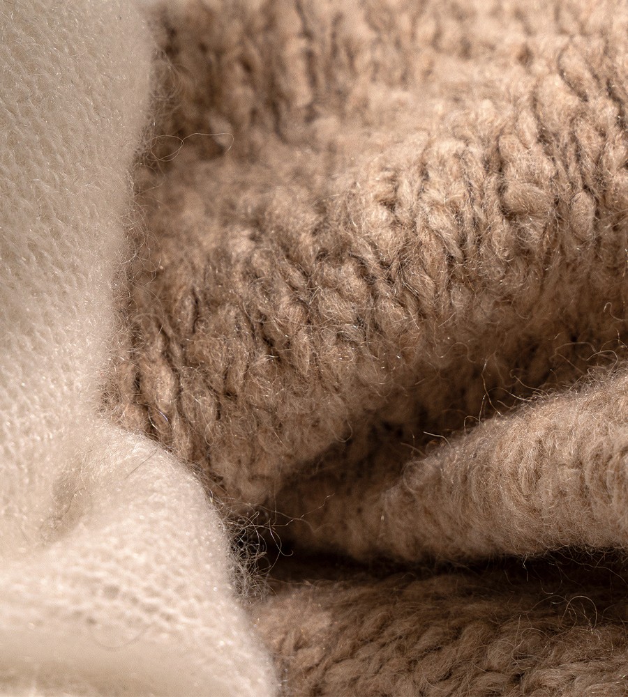 Kvinna och man går längst med strandkanten och bär linneplagg