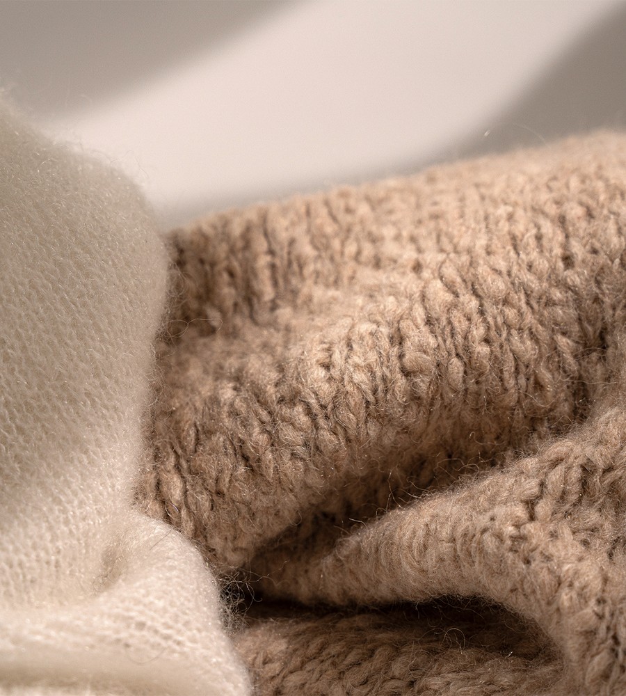 Kvinna och man går längst med strandkanten och bär linneplagg