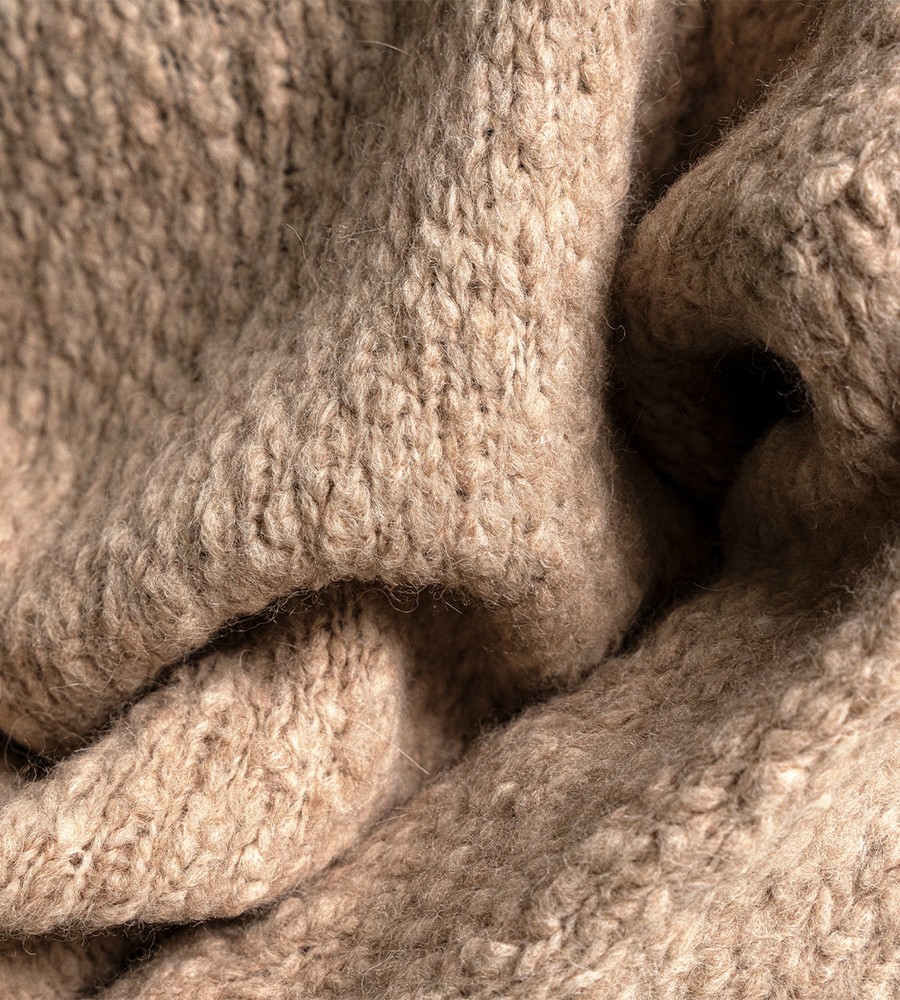 Kvinna och man går längst med strandkanten och bär linneplagg