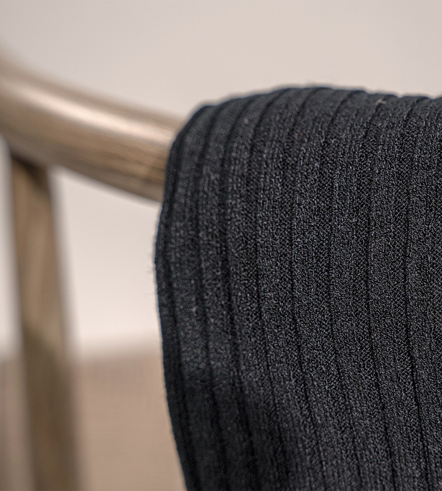 Kvinna och man går längst med strandkanten och bär linneplagg