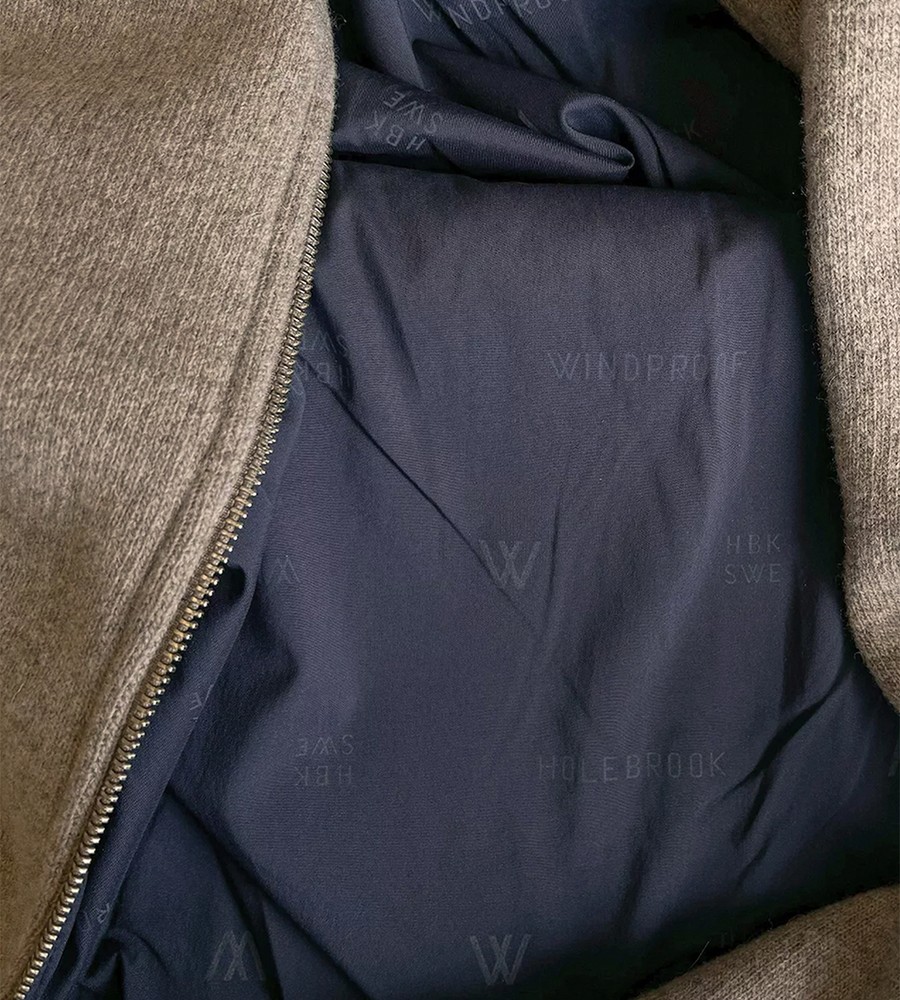 Kvinna och man går längst med strandkanten och bär linneplagg