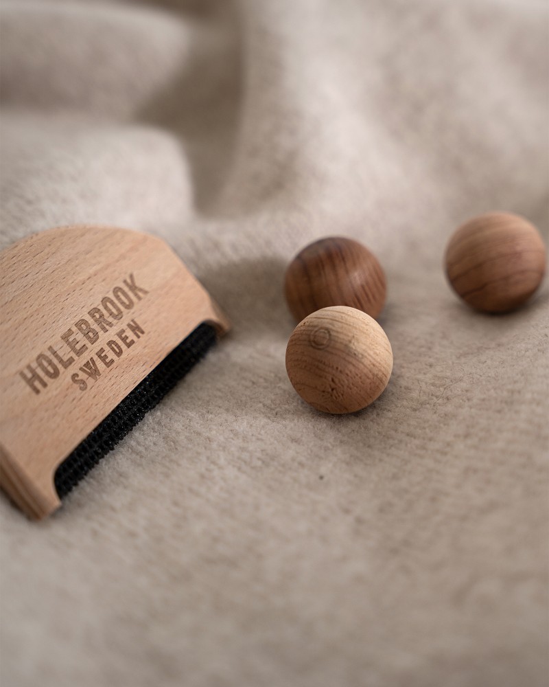 Kvinna och man går längst med strandkanten och bär linneplagg