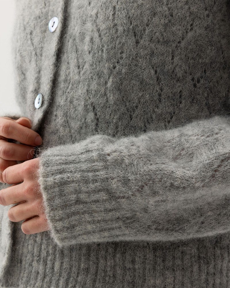 Kvinna och man går längst med strandkanten och bär linneplagg