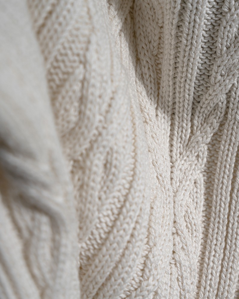 Kvinna och man går längst med strandkanten och bär linneplagg