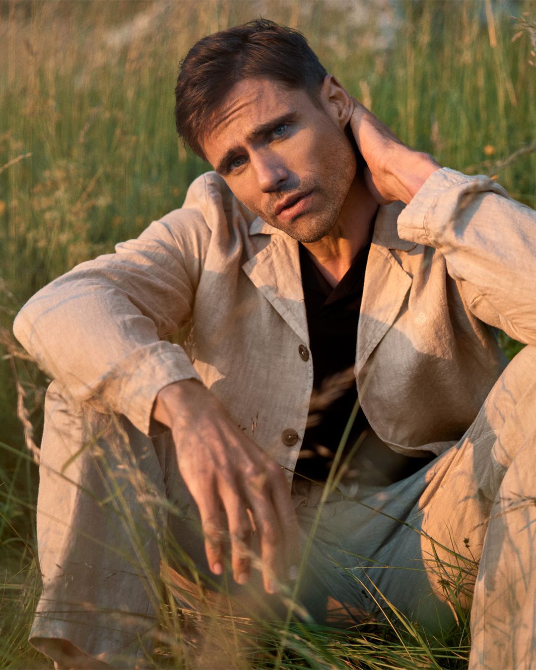 Kvinna ligger i gräset med linneplagg