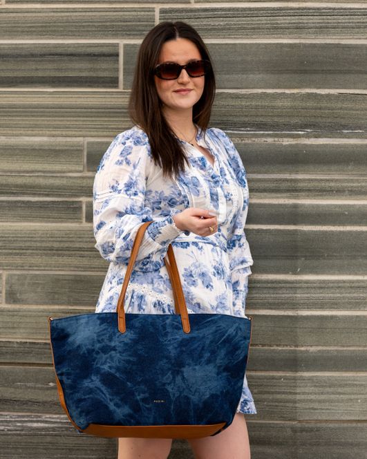 Dame med lys blomsterkjole og en møsk blå vekse i Jeans