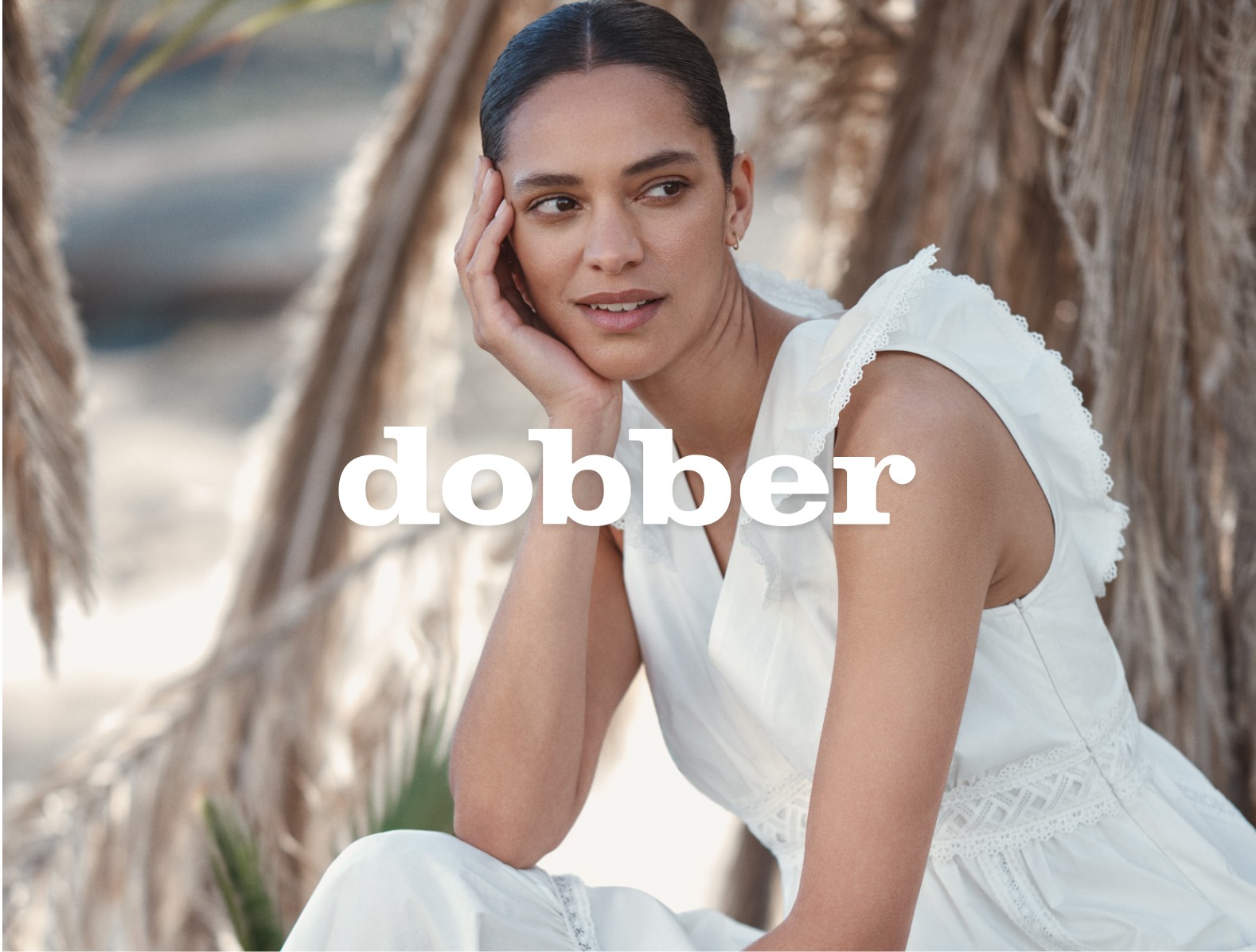 Kvinde i hvid kjole fra mærket Dobber. En klassisk model til et stilfuldt sommerlook.