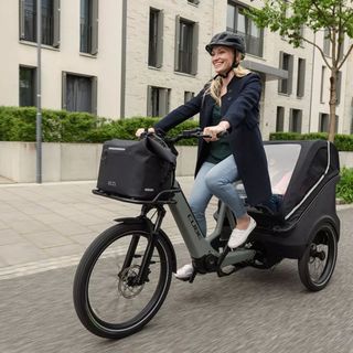 Nainen ajaa Cube Trike-laatikkopyörällä kaupungissa.