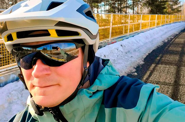 Pyöräilijä päässään pyöräilykypärä ja -lasit.