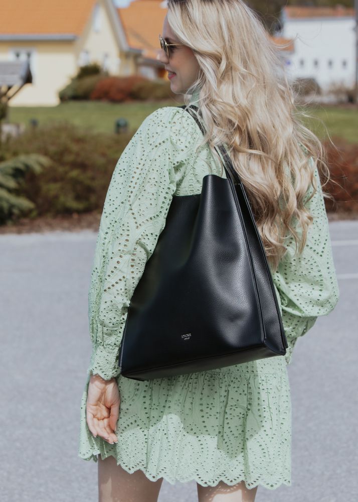 Jente i sommerlig mintgrønn kjole med sort Lycke totebag