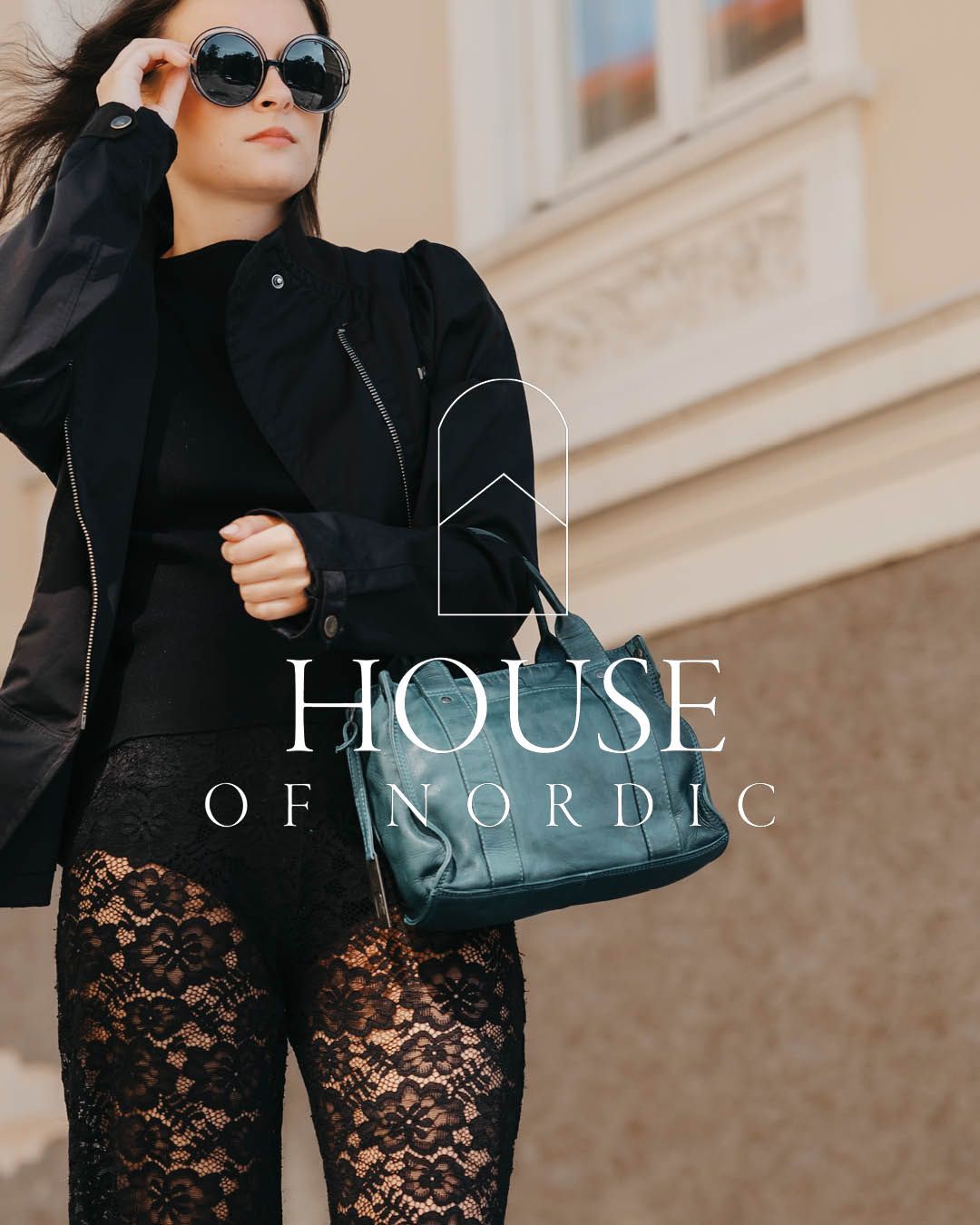 ung dame med veske i petrol blå skinn, i elegant bymiljø, house of nordic logo